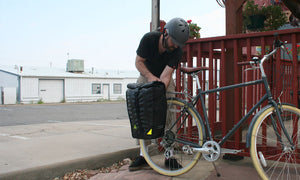 man attaching bike bag to rear rack green guru upcycled